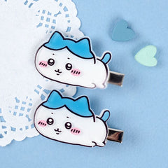 Two cartoon-style hair clips with blue bows on a light blue background.