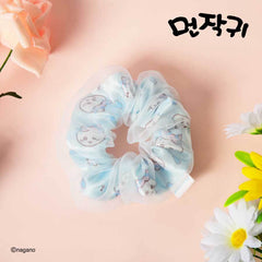Light blue scrunchie with cartoon designs on a pink background with flowers